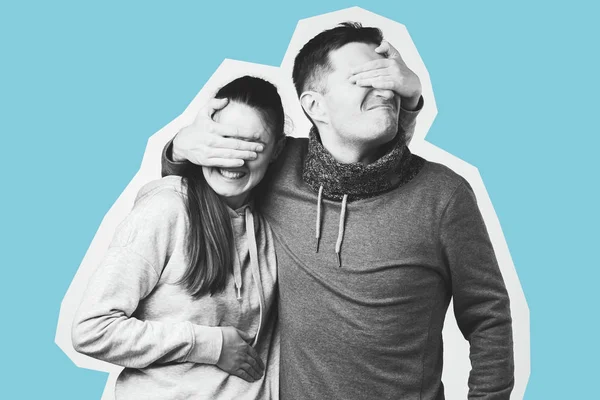Retrato de um jovem casal feliz, homem e mulher cobrindo os olhos um do outro . — Fotografia de Stock