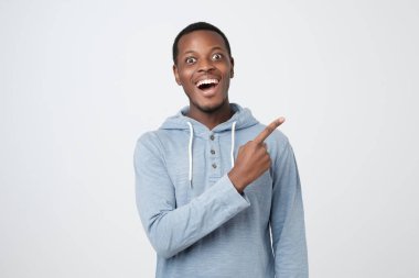 Gülümseyen ve bir kenara parmak işaret genç Afrika adam