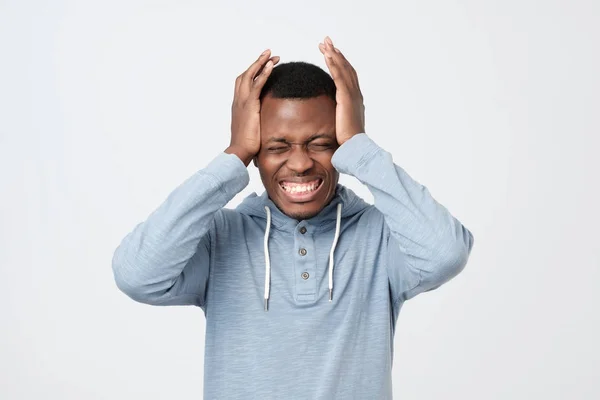 African american man feeling severe headache. He is suffering, holding his head with both hands — Stock Photo, Image