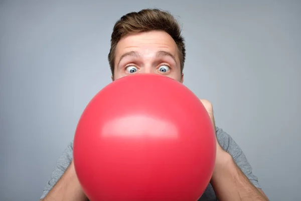 Evropský mladík vyhodí červený balónek — Stock fotografie