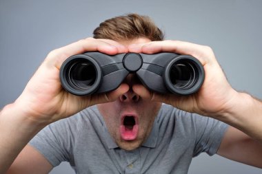 sürpriz dürbünle bakarak adam. Stüdyo çekimi