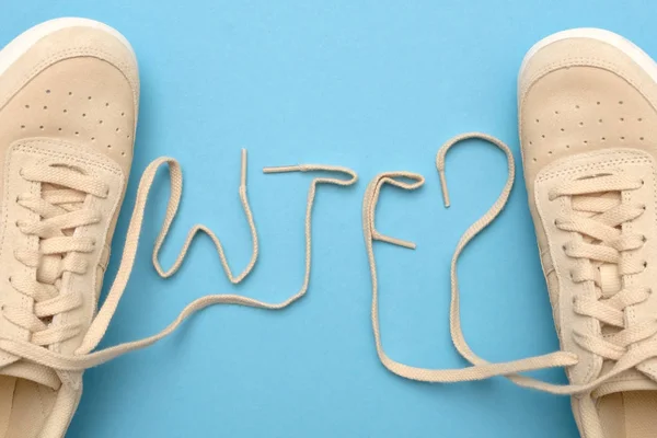 Γυναίκες αθλητικά παπούτσια με κορδόνια στο κείμενο τι στο διάλο. — Φωτογραφία Αρχείου
