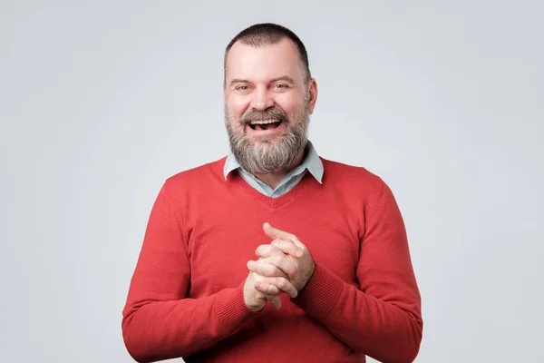 Красивый взрослый бородатый мужчина в красном свитере смеется — стоковое фото