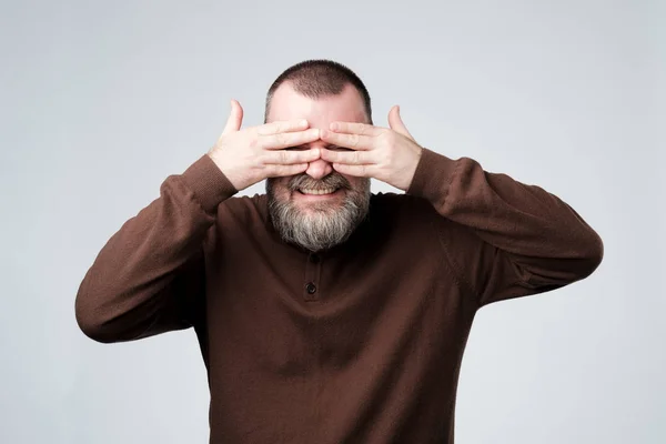 Europea madura hombre cubriendo su cara por las manos — Foto de Stock