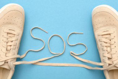 Sos metninde bağcıklı yeni kadın spor ayakkabıları. Ruhlarımızı kurtarın.