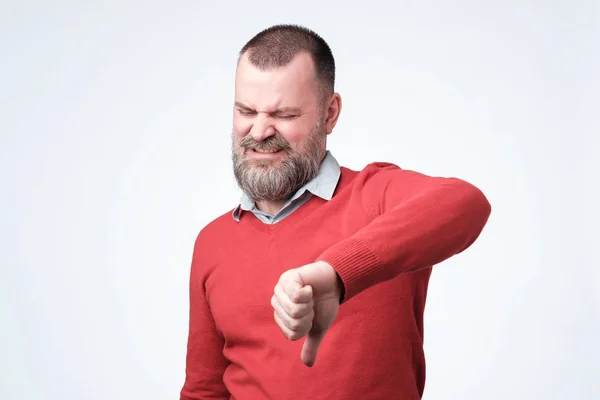 Hombre en suéter rojo da vthumbs gesto hacia abajo . — Foto de Stock