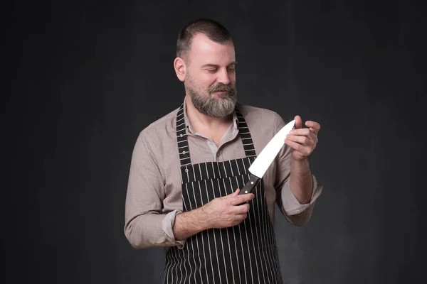 Cocinero maduro en delantal cuchillo de cocina de control de calidad —  Fotos de Stock