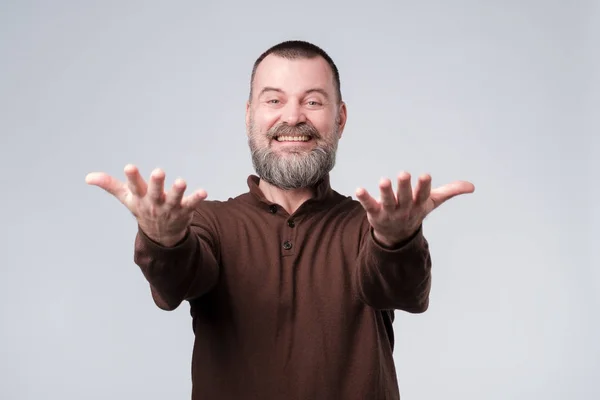 Éxito emociones positivas. Feliz hombre maduro con barba extendiendo las manos por delante — Foto de Stock