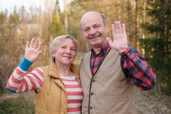 Parents saying bye bye to their children waving hands. — Stock Photo, Image