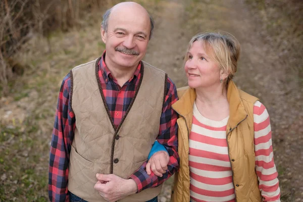 Senior kvinna och man går i parken — Stockfoto