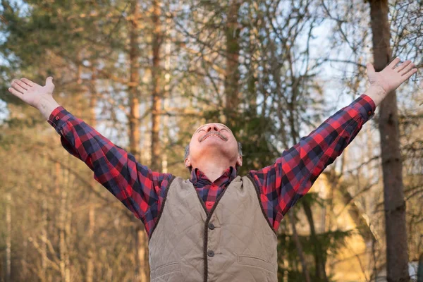 Hombre maduro disfrutando de la vida al aire libre levantando manos . — Foto de Stock