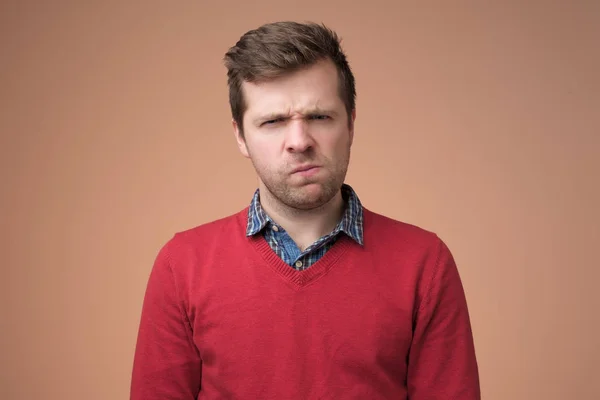 不信感の表情で見える赤いセーターの成熟した男 — ストック写真