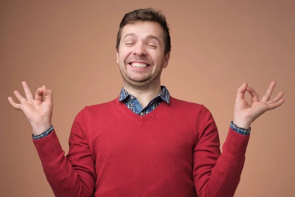 Guy mediterar med upphöjda händer och Zen gest — Stockfoto