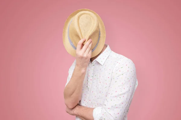 Een jonge Europese man verbergt zich achter zijn hoed — Stockfoto