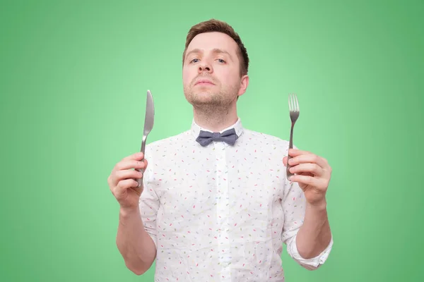 Hombre hambriento sosteniendo tenedor y cuchillo en la mano para comer —  Fotos de Stock