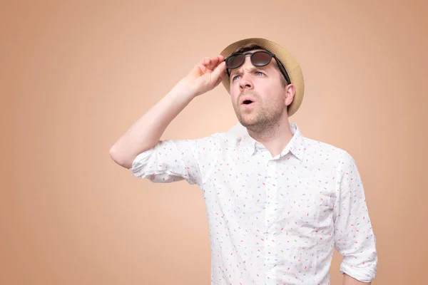 Sorprendido hombre sorprendido en sombrero de verano tocando sus gafas —  Fotos de Stock