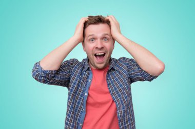 Stüdyoda şok olmuş yüz ifadesi olan genç bir adam.