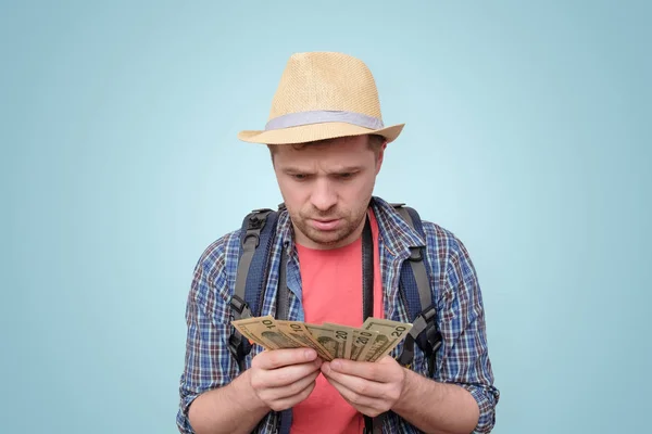 Young tourist man in summer hat holding dollars — Stock Photo, Image