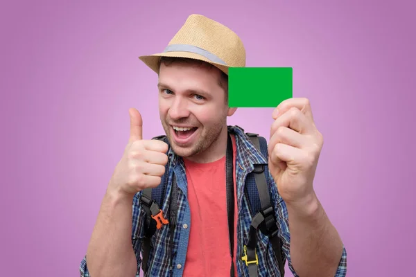 Young handsome tourist man holds green credit card. — Stock Photo, Image
