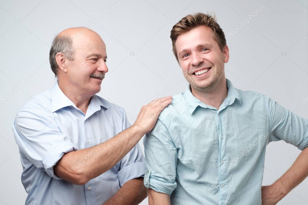 Cheerful father and son looking at each other smiling