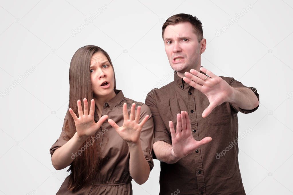 Young european couple showing refusal gesture to stop