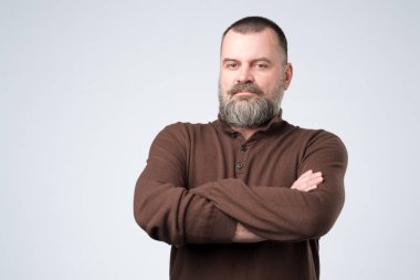 Ciddi olgun Avrupalı adam kolları katlanmış ayakta