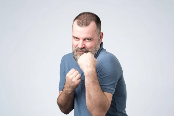 Hombre de camisa azul de pie en pose de boxeador con puño levantado — Foto de Stock