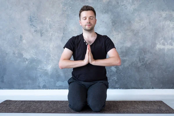 Junger sportlicher Mann praktiziert Yoga-Unterricht sitzend in Vajrasana-Pose — Stockfoto