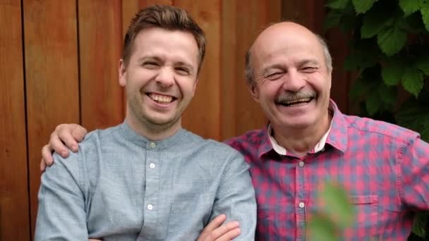 Vrolijke Senior man met zijn zoon staand buiten tijdens zonnige dag — Stockvideo