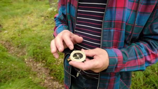 Man Explorer zoeken richting met kompas in zomerbos — Stockvideo