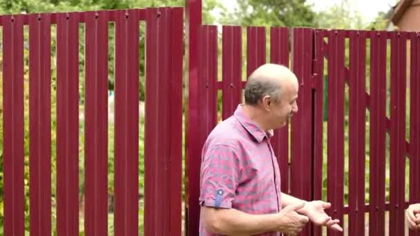 Güneşli günde iki çiftçi takling birbirlerine. Onlar önemli haberleri tartışmak — Stok video