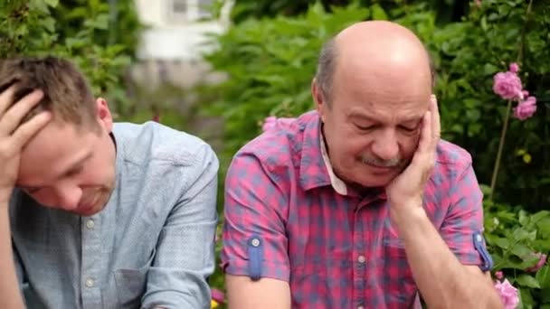 Father and son sitting outdoor being sad and dissapointed with news — Stock Video