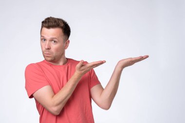 Mutlu adam kameraya bakıyor, gülümsüyor ve eliyle bir kenara bakıyor..