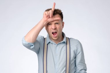 mutsuz adam 30s kamera üzerinde poz ve alnında kaybeden işareti gösteren