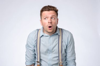 Şaşkın Goofy genç adam bir kenara sürpriz bakıyor.