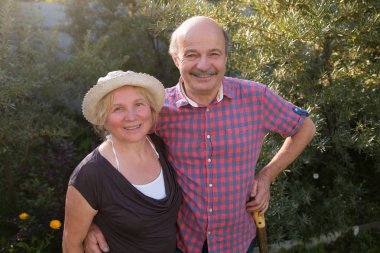 Yeşil yaz bahçesinde dinlenmek neşeli olgun çift