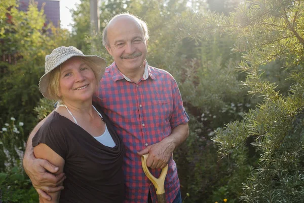 Fröhliches älteres Paar ruht sich im grünen Sommergarten aus — Stockfoto