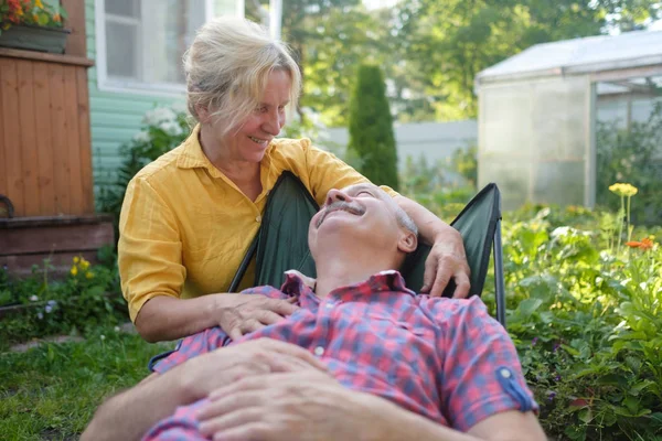 Fröhliches älteres Paar ruht sich im grünen Sommergarten aus — Stockfoto