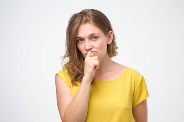 genç kadın şüphe ile görünüyor sarı t shirt giyer, doğru karar vermeye çalışıyor