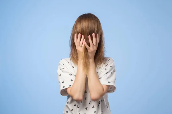 Jeune femme cache son visage avec les cheveux et les mains — Photo