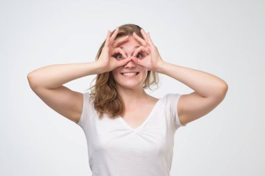 Gözlük gibi gözleri yakın ok işareti parmakları tutan sürpriz yüzü ile kız.