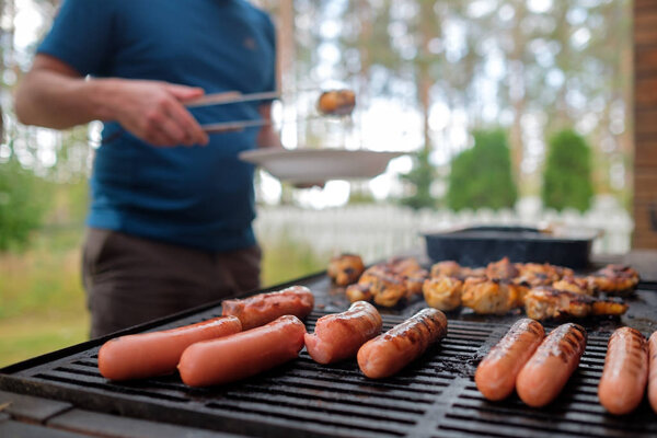 Delicious sausages and chicken legs are fried on bbq