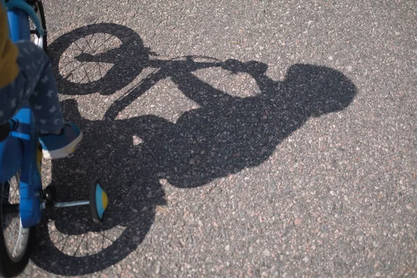 Σκιά του παιδιού ιππασία ποδήλατο στο έδαφος. — Φωτογραφία Αρχείου