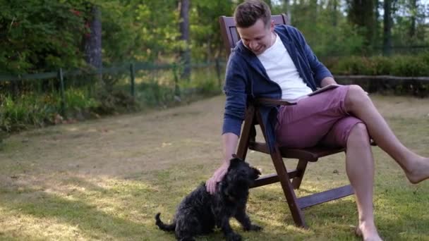 Ägare smekande försiktigt hans hund svart Schnauzer — Stockvideo