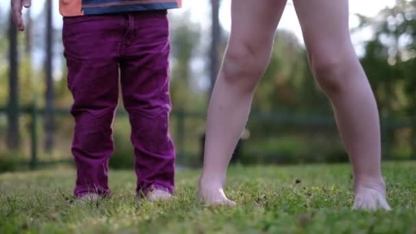 Dzieci nogi na zielonej trawie stojący na zewnątrz. — Wideo stockowe