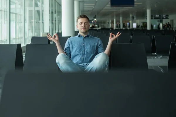 Зрілий чоловік в аеропорту медитує перед польотом — стокове фото