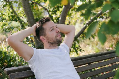 Genç yakışıklı adam şehir parkında oturan bir şeyin hayalini kuruyor..