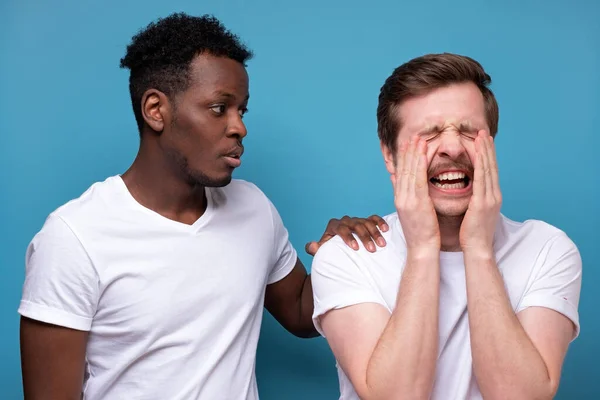 Hombre afroamericano calma a su colega o amigo, que tiene problemas, expresiones faciales miserables —  Fotos de Stock