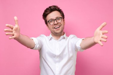 Adam sana doğru elini çekiyor kameraya dostça gülümsüyor sarılmak istiyor.