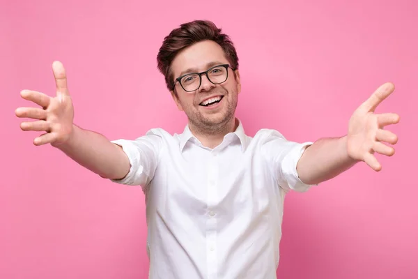 Hombre tirando de las manos hacia usted sonriendo amigable en la cámara con ganas de abrazo — Foto de Stock